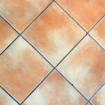 Acqua ossigenata versata su una fuga di piastrelle per pulirla e renderla bianca.