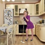 Donna che pulisce una stanza seguendo la regola dei 10 minuti, con attrezzi e prodotti naturali.