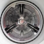 Filtro della lavatrice sporco, pronto per essere pulito seguendo i consigli di un tecnico.