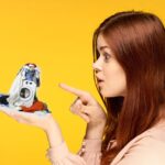 Uomo che controlla e pulisce la lavatrice durante la manutenzione fai da te.