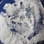 Ingredienti per pastiglie fai da te per lavastoviglie su un tavolo, con utensili e contenitori.