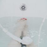 Scarico doccia lento con acqua stagnante e tubi visibili, evidenziando il problema di ostruzione.